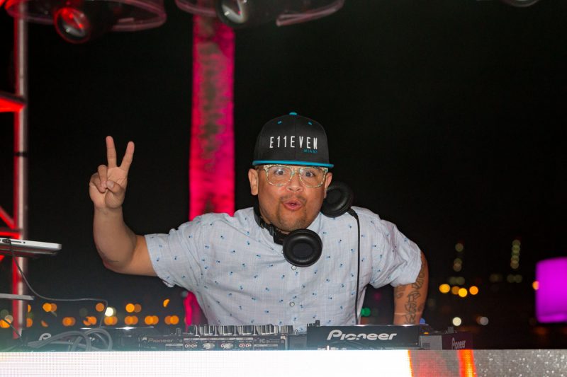 DJ spinning music and flashing a peace sign
