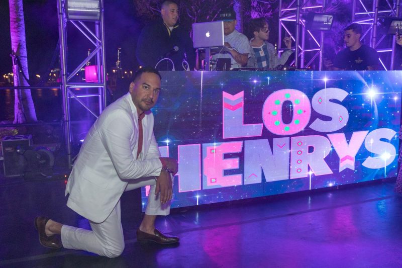 Party guest taking a knee next to the  Los Henrys display